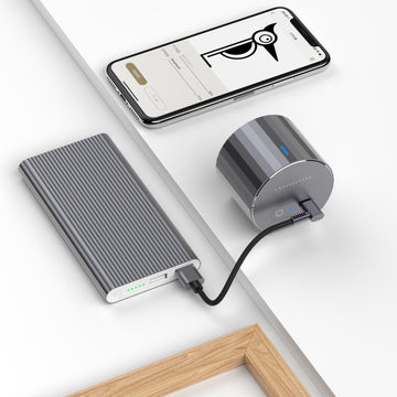 LaserPecker portable cylindrical engraver, powered by an external power bank for untethered use, paired with a smartphone app for design editing, enabling on-the-go creative engraving anywhere.