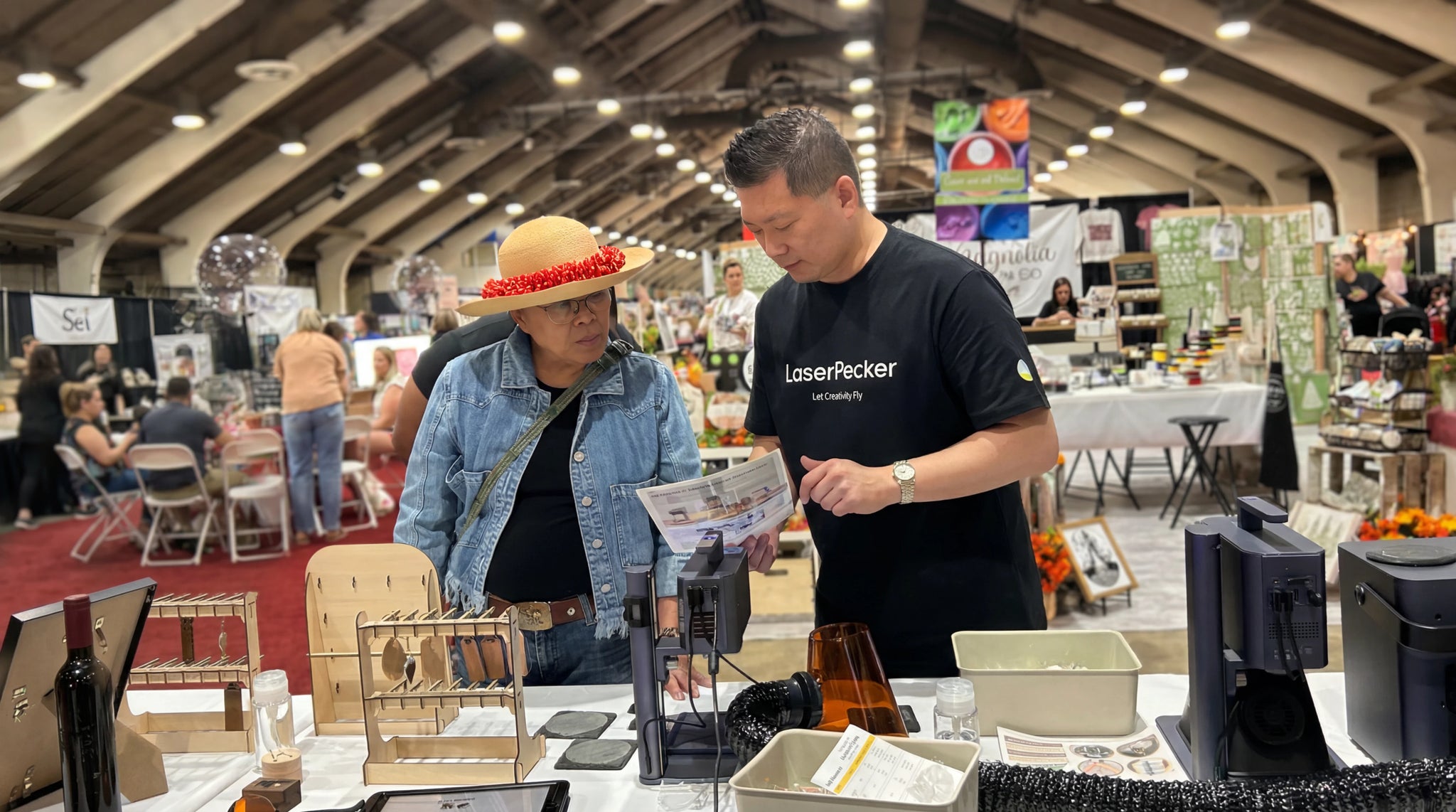 A LaserPecker staff member explaining the machine to a customer.