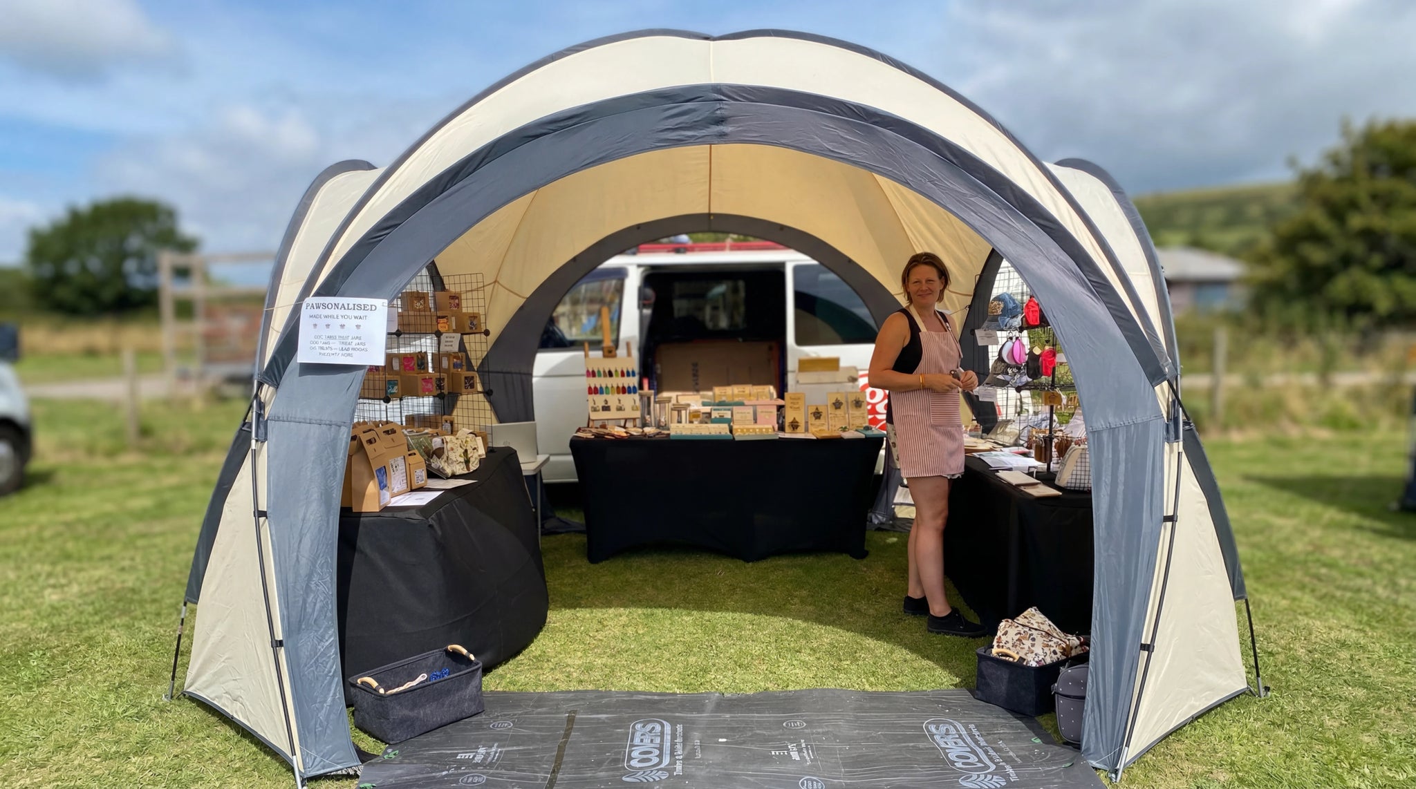 A booth showcasing handmade and engraved items, with the seller beside the display.