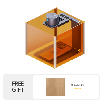 LaserPecker engraver inside an amber safety enclosure that blocks laser radiation, safely engraving a wooden phone case, bundled with a free 3-piece materials kit.